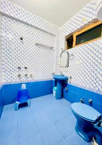 a bathroom with a blue toilet and a sink at Grand view lodge and Restaurant Dharamshala - Partial Prepayment required to confirm booking in Dharamshala