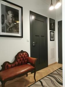 Zimmer mit einer Lederbank und einer Tür in der Unterkunft Green&Wood in Puck