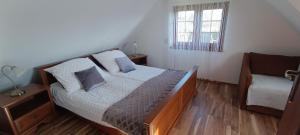 1 dormitorio con cama, ventana y silla en Diament Rogowo, en Rogowo