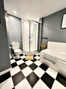 a black and white bathroom with a shower and a toilet at 1 The Cairn Kilmartin - Beautiful Victorian Flat, Pet Friendly in Kilmartin