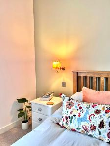 a bedroom with a bed with a nightstand and a lamp at 1 The Cairn Kilmartin - Beautiful Victorian Flat, Pet Friendly in Kilmartin