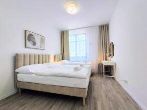 a bedroom with a bed with white sheets and a window at Cinnamon - free private parking - old town - air conditioning in Bratislava