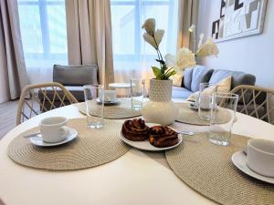 a white table with plates of food on it at Cinnamon - free private parking - old town - air conditioning in Bratislava