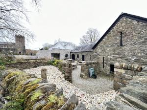 an old stone building with a stone wall next to it at 1 The Cairn Kilmartin - Beautiful Victorian Flat, Pet Friendly in Kilmartin