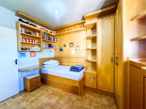 ein kleines Zimmer mit einem Bett und einem Bücherregal in der Unterkunft Casa na Praia dos Ingleses para até 12 pessoas in Florianópolis