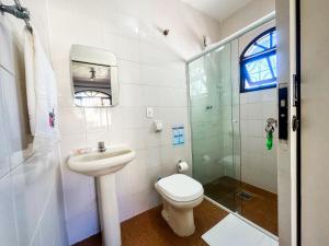 ein Badezimmer mit Toilette, Waschbecken und Dusche in der Unterkunft Casa na Praia dos Ingleses para até 12 pessoas in Florianópolis