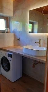 a bathroom with a sink and a washing machine at Lawendowe Narie in Kretowiny