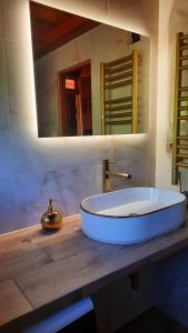 a bathroom with a large white sink on a wooden counter at Lawendowe Narie in Kretowiny