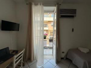 a bedroom with a bed and a window with a balcony at Angolo Lamia Sicily Apartment in Partinico
