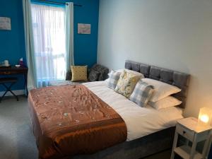 una camera da letto con un grande letto con pareti blu di Selwyn Stays a Liverpool