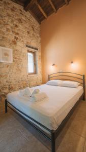 a bedroom with a large bed in a stone wall at Stone Made 3 Private Villa Kriopigi in Kriopigi