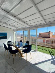 a dining room with a table and chairs on a balcony at ARENA & MAR in El Campello +19 photos