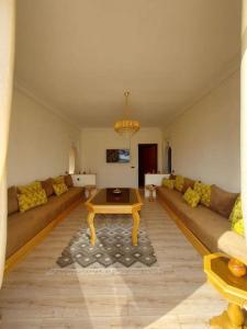 ein Wohnzimmer mit einem Sofa und einem Couchtisch in der Unterkunft Spacious villa in front of the Atlas Mountains in Marrakesch