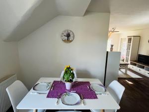 einem weißen Tisch mit weißen Platten und einer Pflanze darauf. in der Unterkunft Apartmány 68 in Kámen