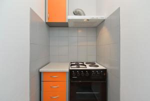 a small kitchen with orange cabinets and a stove at Ferienwohnung für 5 Personen ca 70 qm in Stinjan, Istrien Istrische Riviera in Štinjan