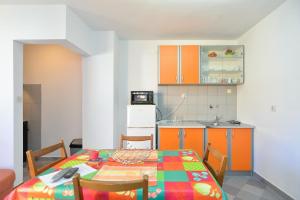 a kitchen with a table and a kitchen with orange cabinets at Ferienwohnung für 5 Personen ca 70 qm in Stinjan, Istrien Istrische Riviera in Štinjan