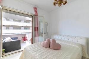 ein Schlafzimmer mit einem weißen Bett mit zwei rosa Herzen darauf in der Unterkunft Suite vista mare in Cattolica