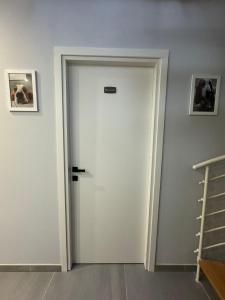 a white door in a room with two pictures on the wall at Alfonsino House in Syracuse