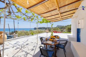 a dining room with a table and chairs and a view of the ocean at Endless Blue Stegna in Archangelos