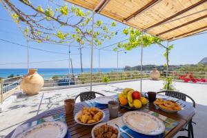 stół z talerzami jedzenia na balkonie w obiekcie Endless Blue Stegna w mieście Archangelos
