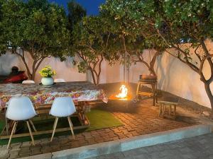 a table and chairs with a fire in a backyard at Villa Oni in Tirana