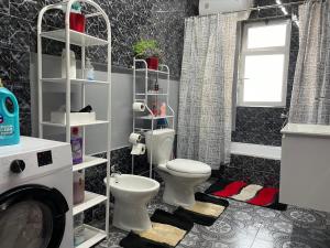 baño con aseo y lavabo y ventana en Villa Oni, en Tirana