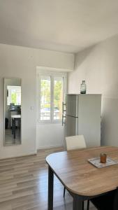 a kitchen with a table and a refrigerator at Charmant T1 entre ville et lac avec balcon in Aix-les-Bains