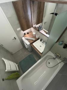 bagno con vasca, lavandino e specchio di Cozy apartment a Bratislava