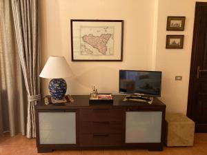 a living room with a tv and a table with a lamp at A Taormina da Paolo in Taormina