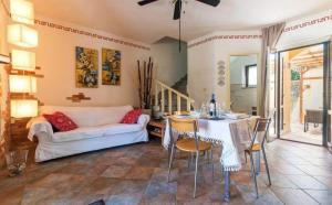 uma sala de estar com uma mesa e um sofá em Ferienwohnung für 4 Personen ca 80 qm in Agrustos, Sardinien Baronie em Porto Ottiolu
