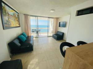 uma sala de estar com um sofá e uma mesa em Apartamento Iroka 10D frente al mar em Santa Marta