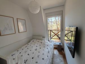 um pequeno quarto com uma cama e uma janela em Apartman Green Divčigora em Divčibare