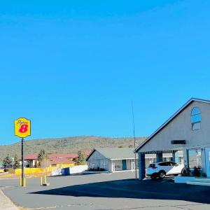 a building with a car parked in a parking lot at Super 8 by Wyndham Williams West Route 66 - Grand Canyon Area in Williams