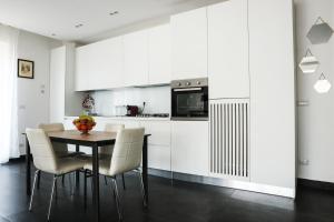 a kitchen with white cabinets and a table and chairs at Attico vista mare in Gaeta