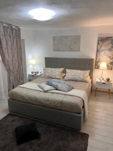 1 dormitorio con 1 cama con 2 mesas y 2 lámparas en Casa Vacanze Manzoni 29 en Cagliari