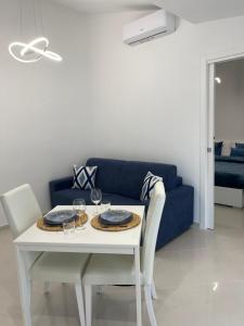 un soggiorno con tavolo e divano blu di La Perla Azzurra a Gaeta