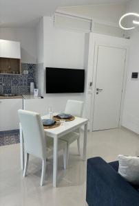 un tavolo bianco e sedie in soggiorno di La Perla Azzurra a Gaeta