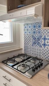 una cucina con piano cottura e piastrelle bianche e blu di La Perla Azzurra a Gaeta