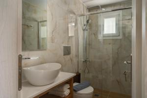 uma casa de banho com um lavatório e uma cabina de duche em vidro. em Molos Beachfront Apartments in Diakopto em Diakopto