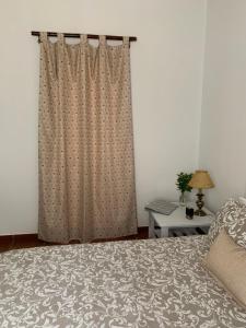 1 dormitorio con 1 cama con cortina y mesa en Monte Sul da Pintada en Montemor-o-Novo