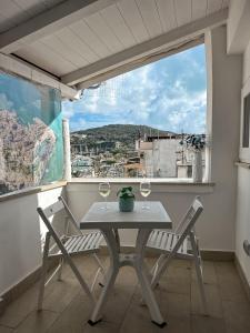 un tavolo e sedie su un balcone con vista di La Perla Azzurra a Gaeta