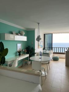 a living room with a table and chairs and the ocean at Sol y Sea Holiday Homes Don Paco in Patalavaca