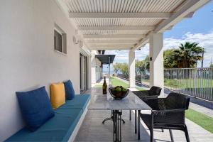 um pátio com um sofá azul e uma mesa em Molos Beachfront Apartments in Diakopto em Diakopto