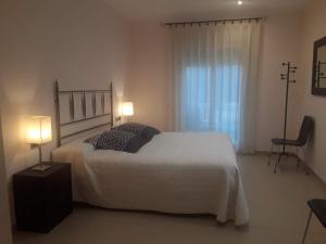 1 dormitorio con 1 cama blanca grande y 2 lámparas en Casa Laure y Mª José, en Arens de Lledó