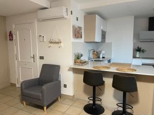 eine Küche mit einer Theke, 2 Stühlen und einer Arbeitsplatte in der Unterkunft Apartamento Kai in Playa Jandia