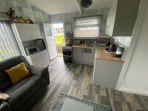 a living room with a couch and a kitchen at 348 Golden Sands in Withernsea