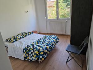 um quarto com uma cama, uma cadeira e uma janela em location appartement 80m2 à Rombas em Rombas