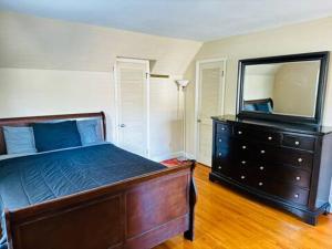 a bedroom with a bed and a dresser with a mirror at In the heart of the QC! in Charlotte