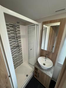 a bathroom with a sink and a shower at Golden Anchor - The Waverley - Coastal Caravan Breaks in Chapel Saint Leonards
