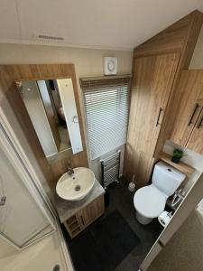 a small bathroom with a toilet and a sink at Golden Anchor - The Waverley - Coastal Caravan Breaks in Chapel Saint Leonards